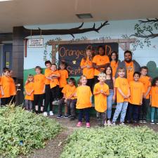 Group of elementary students stand with their ISW in orange shirts
