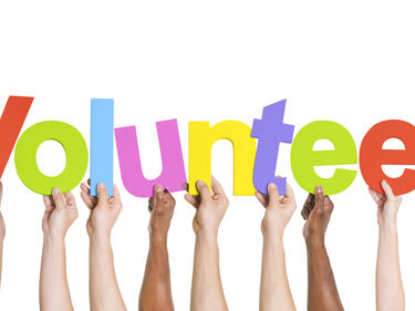 Hands holding a volunteer sign