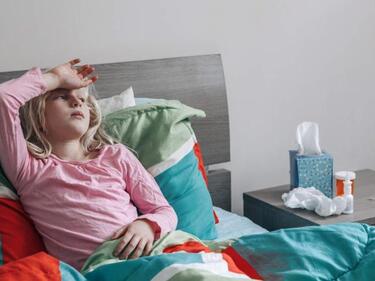 Child lying in bed sick