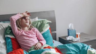 Child lying in bed sick