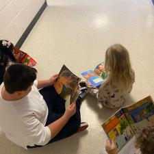 Students reading in on the floor in the hallway