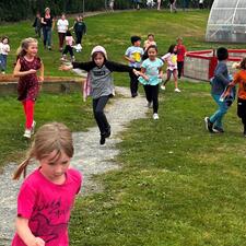 Students and teachers running along a gravel path