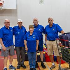 A group of volunteers standing next to filled hampers